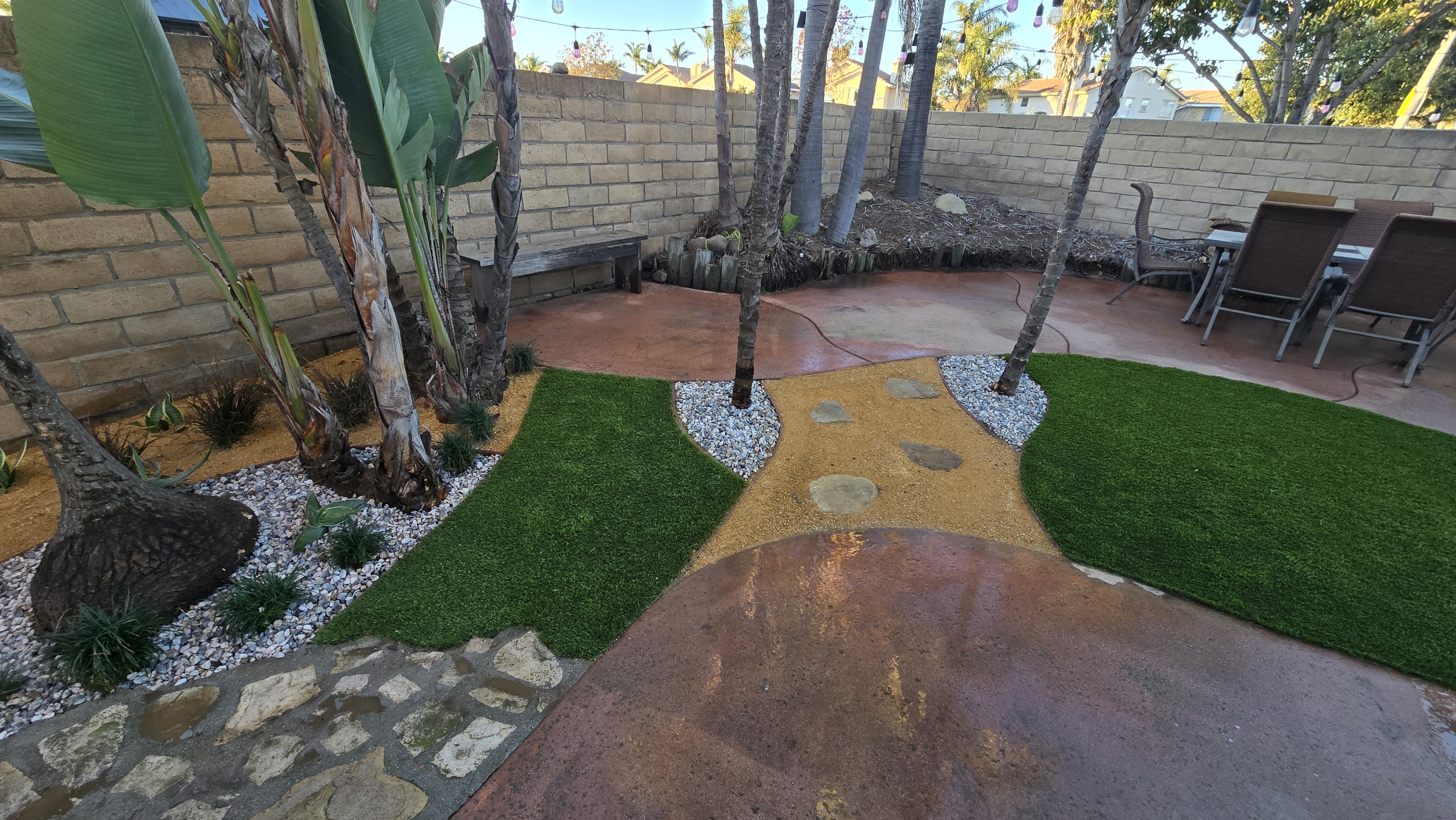 Custom backyard transformation — stained concrete with artificial turf islands